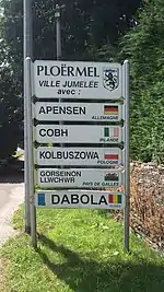 Photographie du panneau indiquant les villes jumelées à Ploërmel.