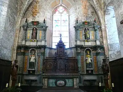 Retable architecturé constitué de deux corps latéraux à double étage et d'un corps central en bois composé du tabernacle, de volets flanqués d'ailerons en volute et couronné d'un dais d'exposition. Jumilhac le grand (24), église saint Pierre ès liens