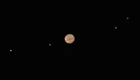 Jupiter est reconnaissable avec ses bandes rouges. Les lunes sont distinguable et non floues mais apparaissent comme des points lumineux.