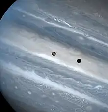 Photo de Jupiter. Io est visible au centre de l'image et son ombre à sa droite.