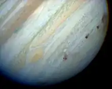 Vue d'une succession de taches sombres alignées dans l'atmosphère de Jupiter.
