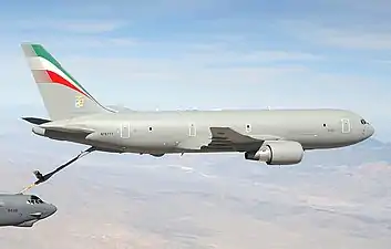 Un KC-767, essentiellement gris, avec la perche de ravitaillement sortie, en train de ravitailler un B-52 visible dans le coin inférieur gauche.