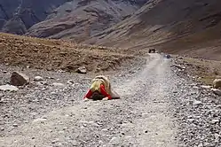 Pèlerin tibétain se prosternant de tout son corps tous les trois pas.