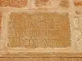 Gros plan sur l'inscription latine (datant de l'époque des Sévères) d'une des pierres remployées à la base du minaret.