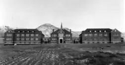 Photographie en noir et blanc d'un long bâtiment.