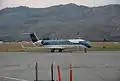 An aircraft located on a runway, with a mountain in the background.