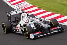 Photographie de Kamui Kobayashi fêtant son premier podium en Formule 1 devant son public