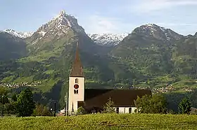 L'église Saint-Gall, avec en arrière plan le Mürtschenstock (en) à gauche, et le Nüenchamm à droite.