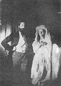 image noir et blanc : une jeune femme en blanc à côté d'un homme barbu
