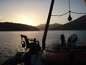 Photographie d'une ria vue depuis un bateau au coucher du soleil.