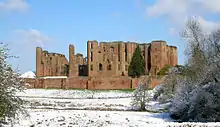 Château médiéval en briques et en ruines, sous la neige.