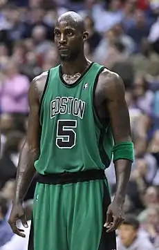 Transpirant dans son uniforme vert et noir, le joueur de basket-ball Kevin Garnett, n°5 des Celtics de Boston, attend la reprise du jeu.