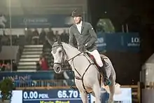 Cheval gris monté dans un bâtiment fermé