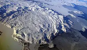 Vue aérienne vers le nord-ouest mettant en évidence la structure circulaire des monts Kiglapait au bord de la côte du Labrador.