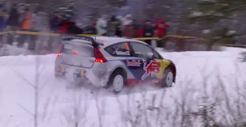 Photo de Kimi Räikkönen en pleine course, fonçant dans la neige au volant d'une Citroën C4 WRC.