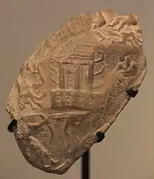 Empreinte de sceau-cylindre : temple orné de cornes, roi-prêtre armé d'un arc combattant des ennemis. Musée du Louvre.