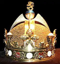 Photo en couleur d'une couronne fermée surmontée d'ornements qui recouvrent le sommet de la tête, au sommet un lion en or