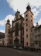 Gaçade baroque à deux clochers d'une église située dans une grande ville.