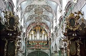 Voûtes et orgue richement décorés d'une église.