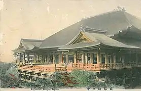 Photo de couleur d'une carte postale colorisée représentant un temple en bois, sur fond clair.
