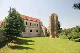 Photographie d'un corps ancien de bâtiment jouxtant un pilier gothique en ruines