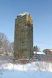 Photographie couleur d'une colonne gothique ruinée recouvert de neige.
