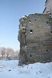 Photographie couleur d'une mur de pierres de taille sous la neige.