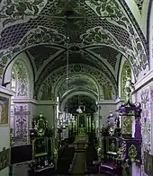 Photographie couleur d'un nef d'église dont les voûtes sont peintes.