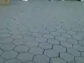 Sol en pavé autobloquant hexagonaux (sans joint) dans la station de métro Knyaginya Maria Luiza à Sofia Metropolitan, en Bulgarie. De même forme, les tomettes sont des carreaux de terre cuite jointoyés.