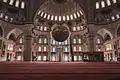 La salle de prière et le mur de la qibla, avec le mihrab et une des quatre demi-coupoles qui contrebutent la coupole centrale.