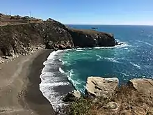 Photo d'une falaise avec en contre-bas une plage.