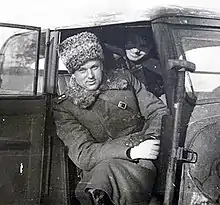 Photographie en noir et blanc d'un homme assis dans un véhicule.