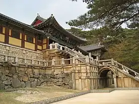 Photographie d'un temple, dont l'accès se fait par un escalier surla partie droite de l'image.