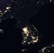 Photographie satellite de la péninsule coréenne de nuit, seul le sud présente des points éclairés.