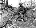 Soldat américain le 25 April 1951 durant la guerre de Corée avec une Carabine M1 et à côté d'une arme soviétique Degtiarev DP 28.