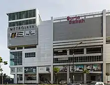 Photographie d'un bâtiment sur lequel il est inscrit à droite de la photographie « Suria Sabah » et à gauche « Metrojaya - Golden Screen Cinemas ».