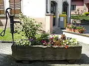 Petite fontaine avec une pompe près de la mairie.