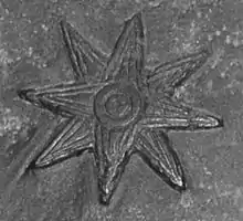 Une étoile est gravée sur une stelle en pierre.