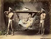 Femme dans un kago porté par deux hommes.