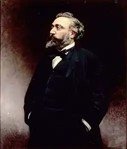 Peinture représentant Léon Gambetta, debout, les mains dans les poches de son pantalon, le corps, visage compris, tourné vers la gauche.