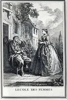 Une femme debout, de profil, devant un homme assis.
