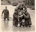 À gauche Jean Pierre Brûlard MPLF[pas clair], Alain Copel, Roger Stella, Jean Pierre Morvan, portant le lieutenant François Raoul sur leurs épaules dans l'oued Bellah en crue.