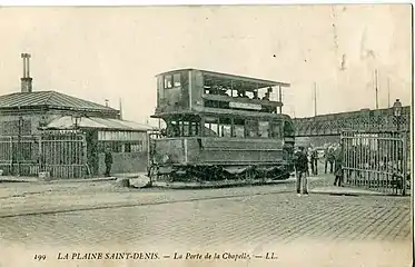 Tramway Saint-Denis - Paris au début du XXe siècle, à la barrière de la porte de la Chapelle. En arrière-plan, le pont Hainguerlot.
