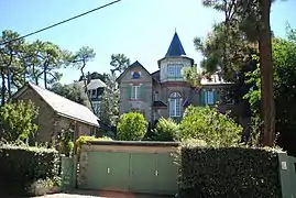 Vue en couleur d'un maison avec une tour surmontée d'un toit pointu en ardoises.