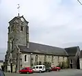 Photographie d'une église dont le clocher a été raccourci après un incendie.