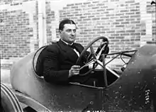 Photo d'un homme, Albert Guyot, au volant d'une voiture roulant à faible allure.