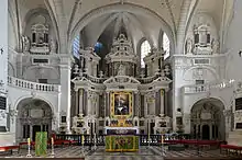 Photographie présentant le retable du chœur, de style baroque.