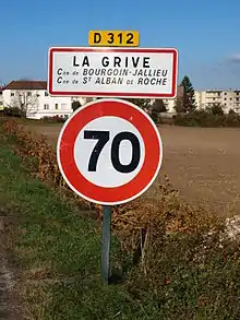 Panneau d'entrée du lieu-dit sur la D 312, précisant que la Grive se partage entre les deux communes. Vitesse limitée à 70 km/h.