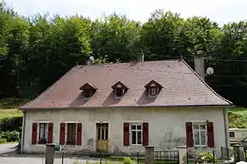 Maison avec un étage sous les combles d'un toit à quatre pans.