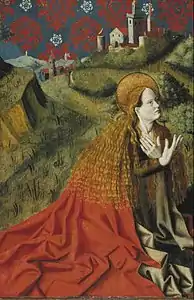 Femme agenouillée, avec un long manteau rouge devant un paysage.